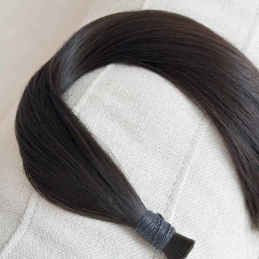 Single hair extension on a textured beige surface