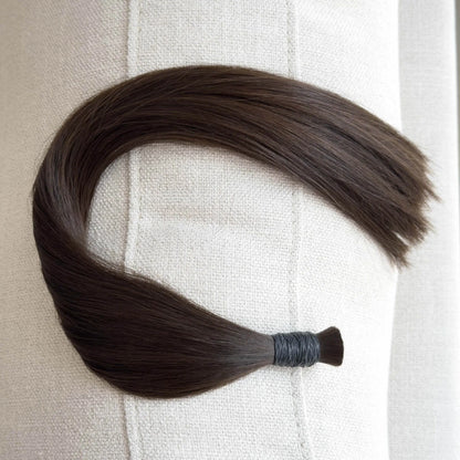 Brown, colour 4 hair extension on a textured beige background