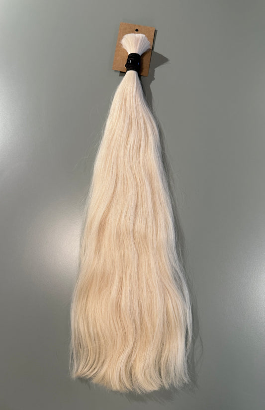 A bundle of long, straight blonde slavic hair extensions with a black band and brown cardboard header, shown against a plain gray background.